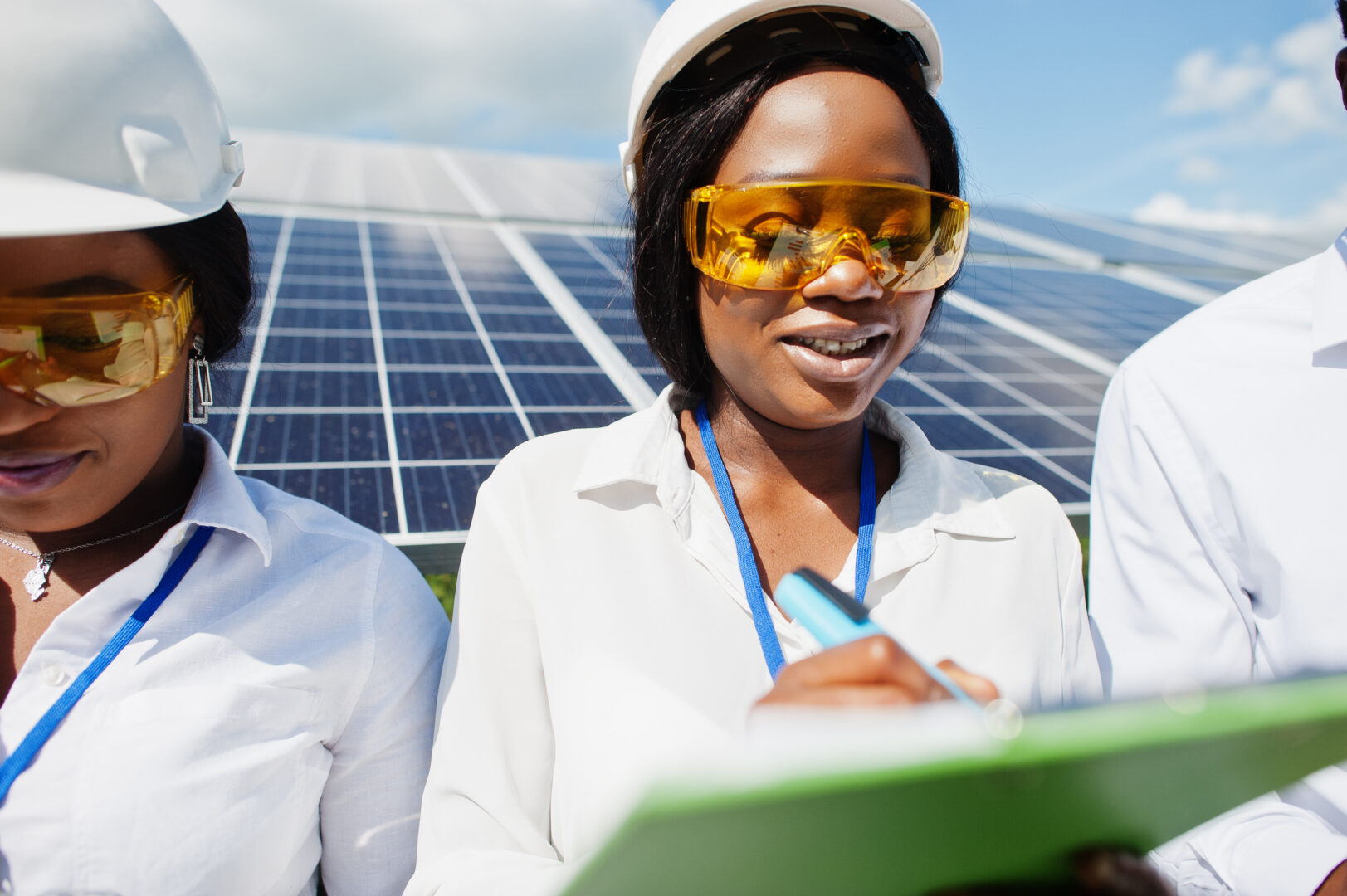 African american technician checks the maintenance of the solar panels. Group of three black engineers meeting at solar station.